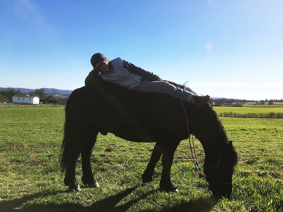 Obéline prend le soleil sur le dos d'un merens-Centre équestre de Najac-Jardin du ptit cheval